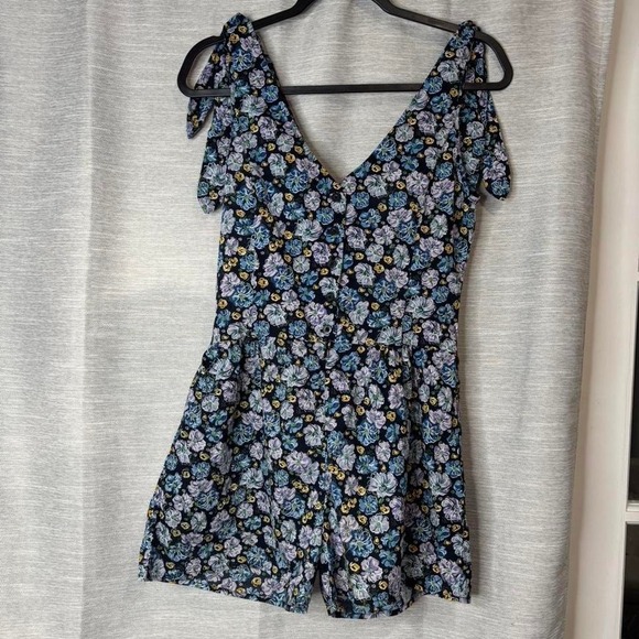 Pants - 'Miley Cyrus navy floral romper with tie detail. Size M